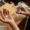 Above view of open palm of young man holding pill over small wooden table before dissolving it in glass of water