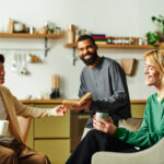 Young men enjoy a lively conversation while reading together in a comfortable living space.