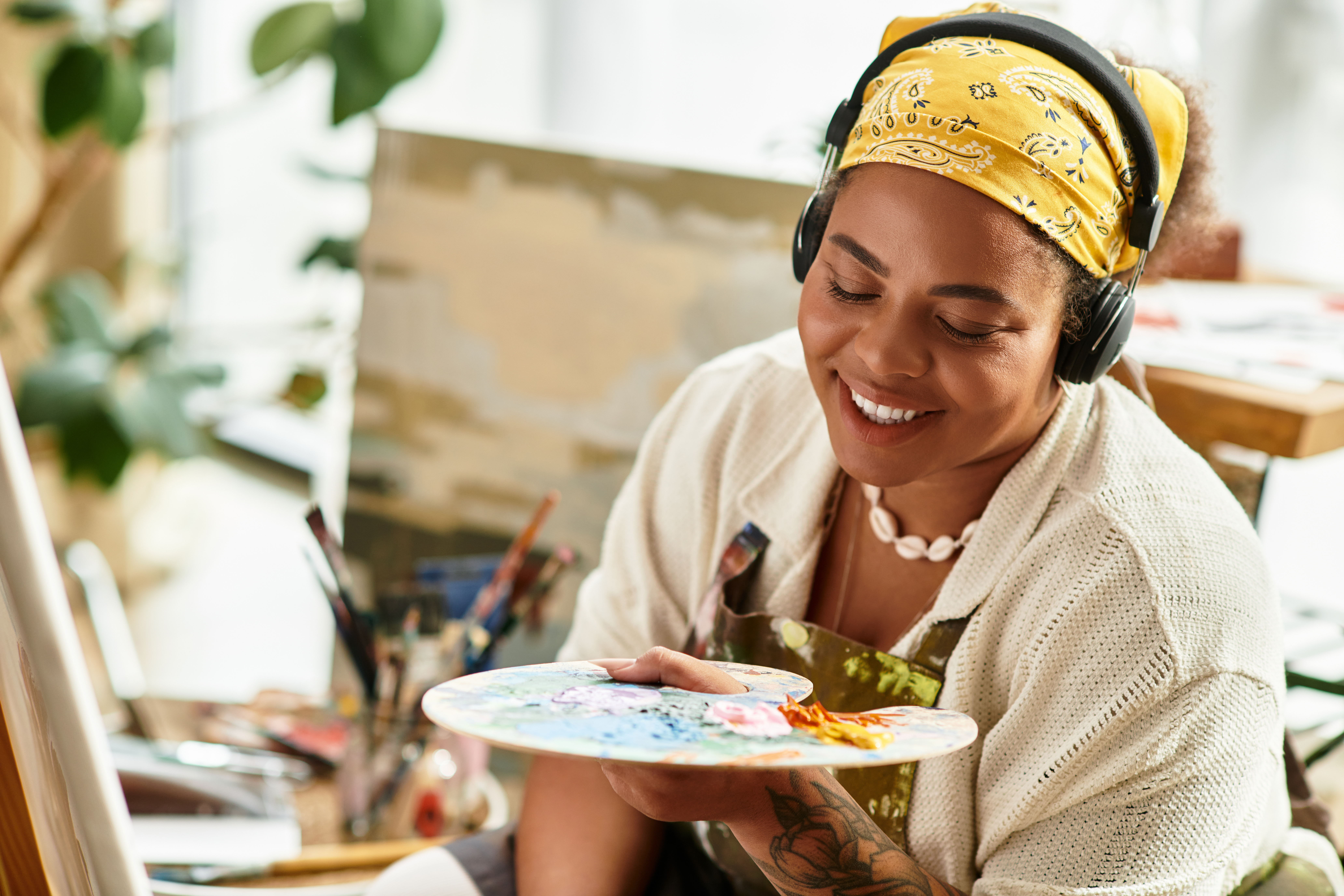 A skilled artist mixes vibrant colors on a palette, smiling with joy at her artistic creation.