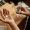 Above view of open palm of young man holding pill over small wooden table before dissolving it in glass of water